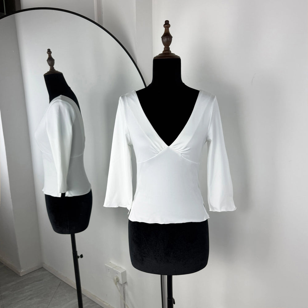 White blouse on a mannequin against a plain background