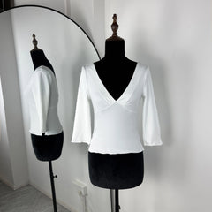 White blouse on a mannequin against a plain background