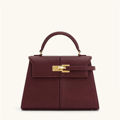 Maroon handbag with gold clasp on a white background