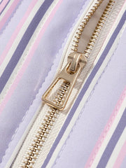 Close-up of a gold zipper on a striped fabric background