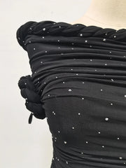Black dress with silver embellishments on a mannequin against a white background