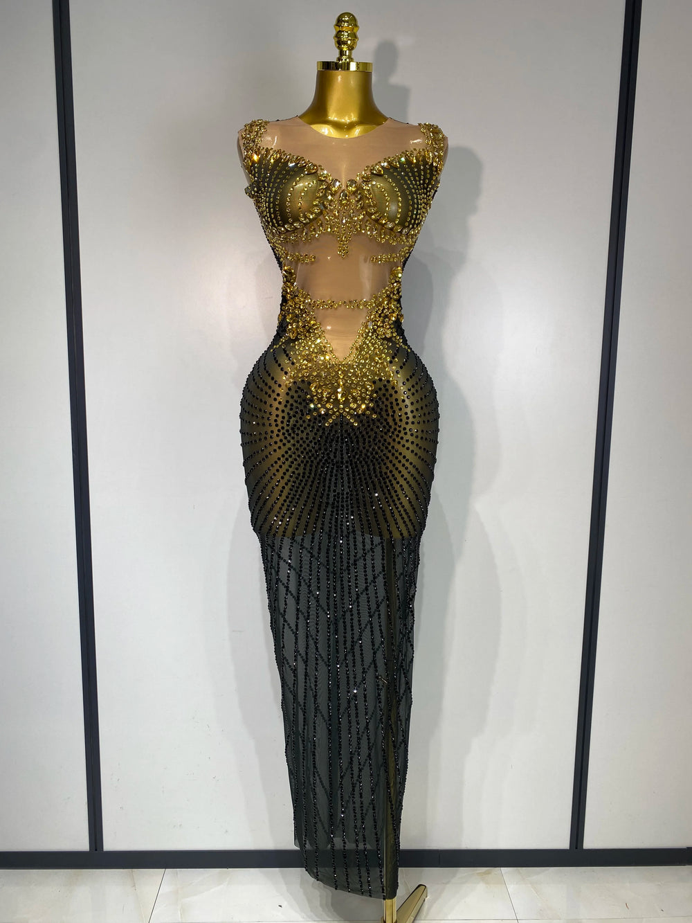 Mannequin wearing a black and gold beaded evening gown against a white background