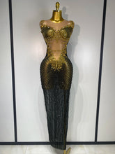 Mannequin wearing a black and gold beaded evening gown against a white background