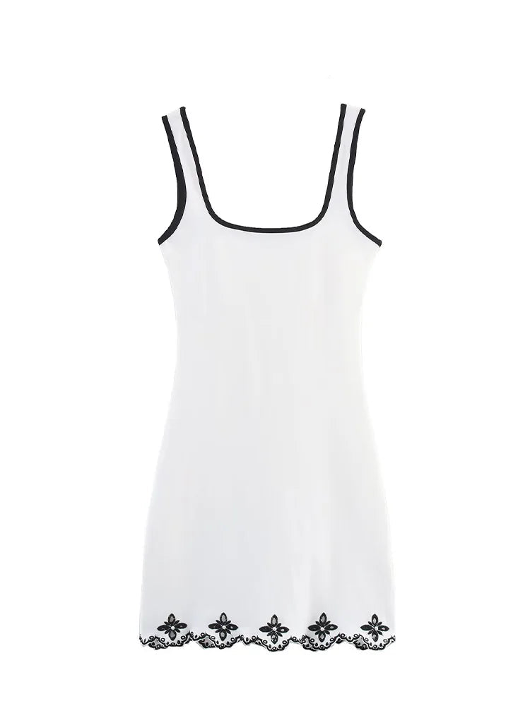 White dress with black lace details on a white background, featuring the brand 'Trafza'.