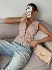 Model wearing pink V-neck lace-up peplum top on a sofa