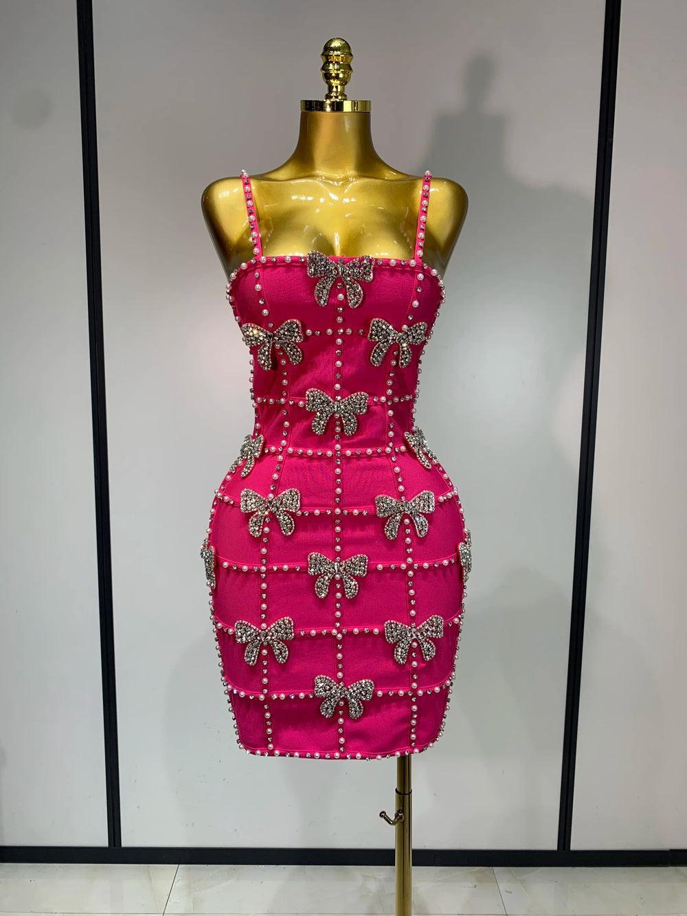 Sleeveless beaded bow mini dress on mannequin
