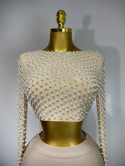 Mannequin wearing a white beaded top with long sleeves on a gray background