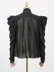 Black sheer blouse on a mannequin with a white background