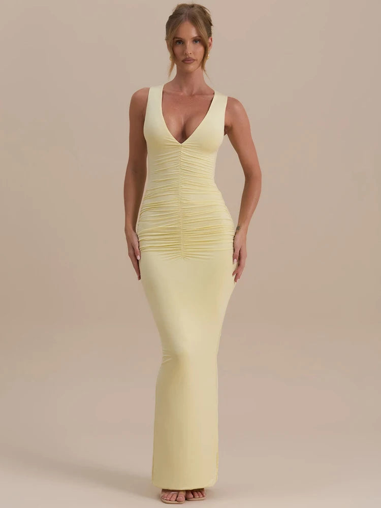 Woman wearing a light yellow evening gown against a beige background
