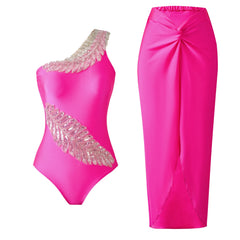 One-shoulder embellished swimsuit with a bright pink hue and matching wrap skirt.