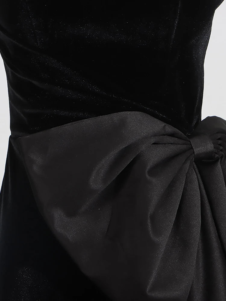 Black dress with a large bow detail on a white background