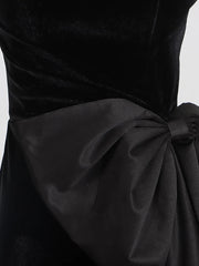 Black dress with a large bow detail on a white background