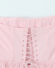 Pink strapless top with lace-up front on a light gray background