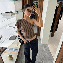 Woman taking a mirror selfie wearing a striped top and jeans in a store.