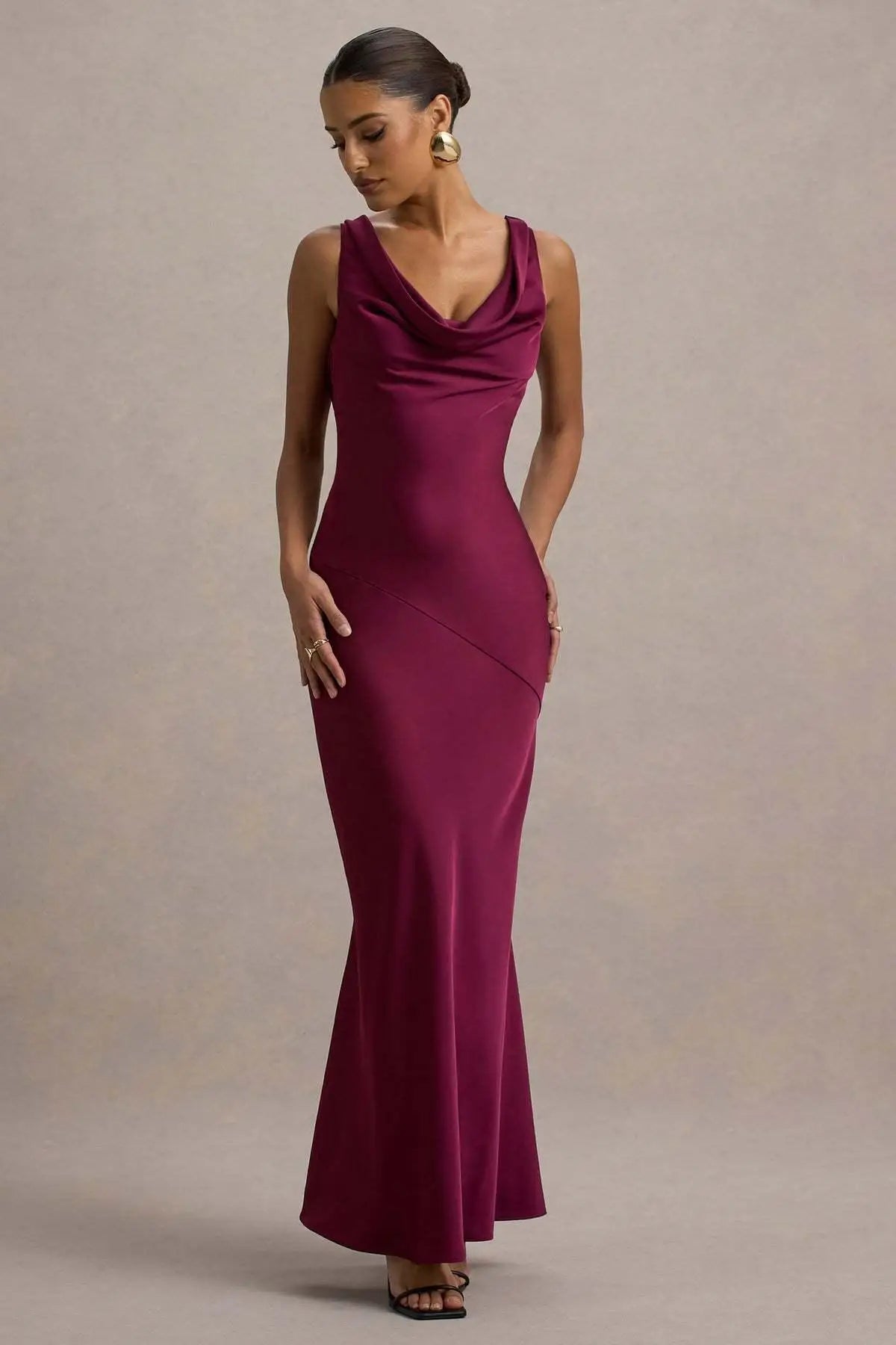 Woman wearing a burgundy evening gown against a neutral background