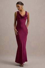 Woman wearing a burgundy evening gown against a neutral background