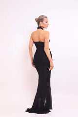 Woman wearing a black halter neck gown on a white background