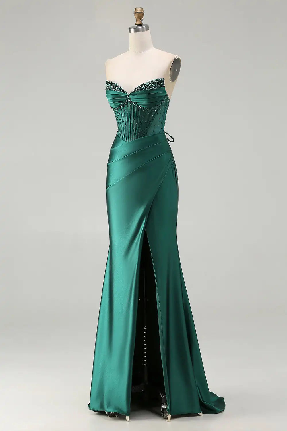 Green evening gown on a mannequin against a white background