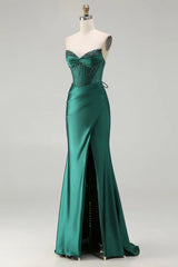 Green evening gown on a mannequin against a white background