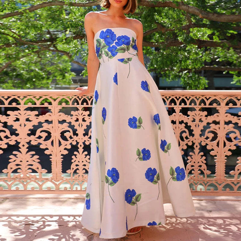Woman wearing a strapless dress with blue floral patterns outdoors.