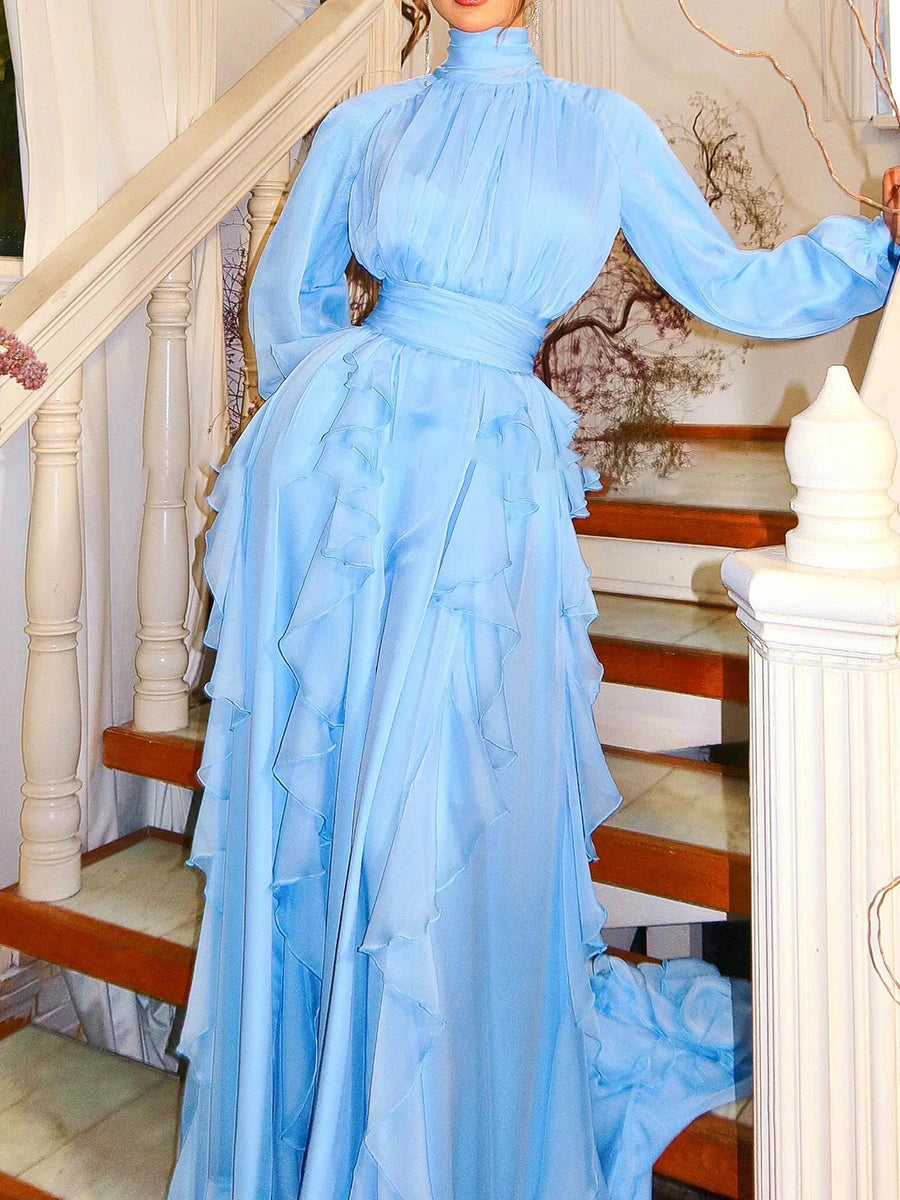 Woman in a light blue dress standing on a staircase