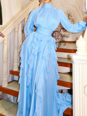 Woman in a light blue dress standing on a staircase