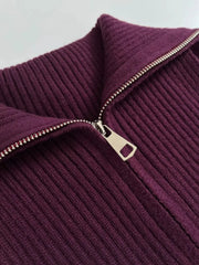 Close-up of a ribbed purple sweater with a zipper on a light gray background