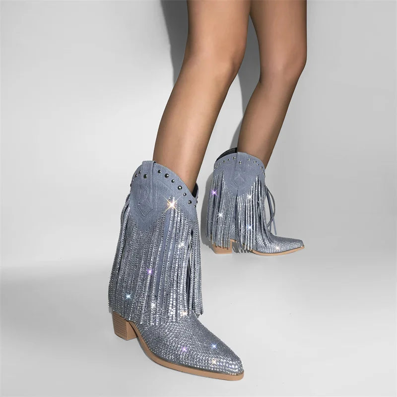 Silver glittery fringe boots worn by a person on a light gray background