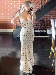 Woman in polka dot cap sleeve maxi dress taking a mirror selfie