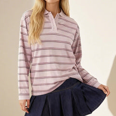 Woman wearing a striped long-sleeve shirt and navy pleated skirt on a beige background