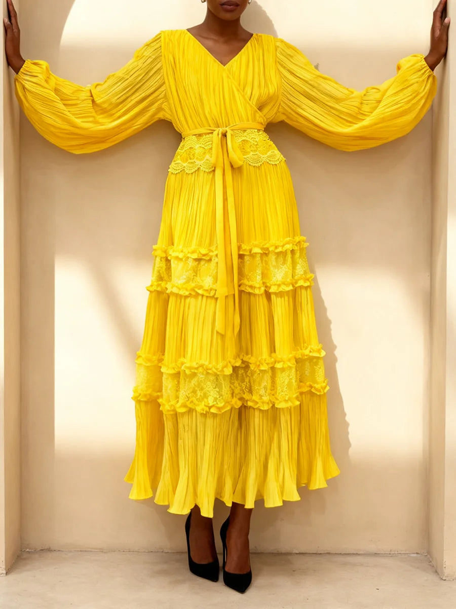 Yellow dress with ruffled layers worn by a person against a neutral background