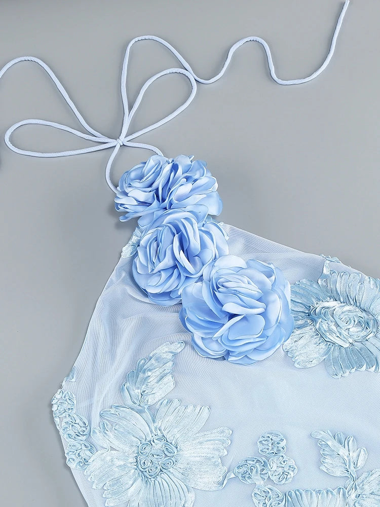 Light blue floral top with lace details on a gray background