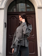 Grey belted double-breasted trench coat worn by a woman