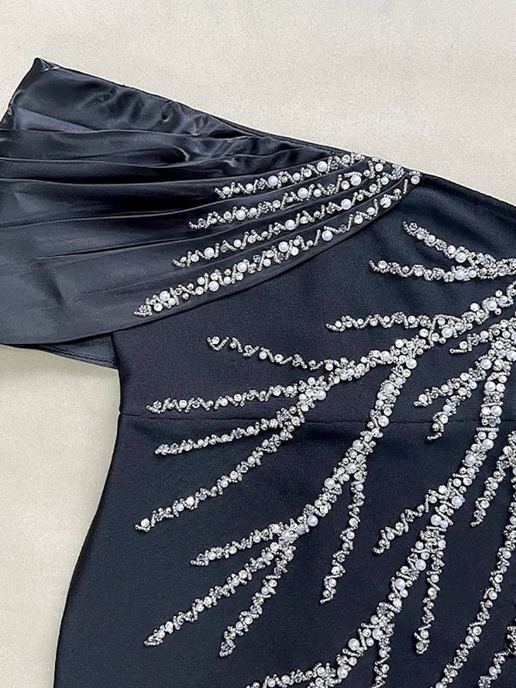 Navy blue dress with silver bead embellishments on a light background