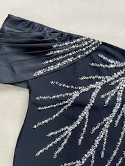 Navy blue dress with silver bead embellishments on a light background