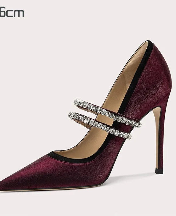 Maroon high-heeled shoe with rhinestone strap on a light gray background