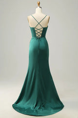 Green evening gown on a mannequin against a plain background
