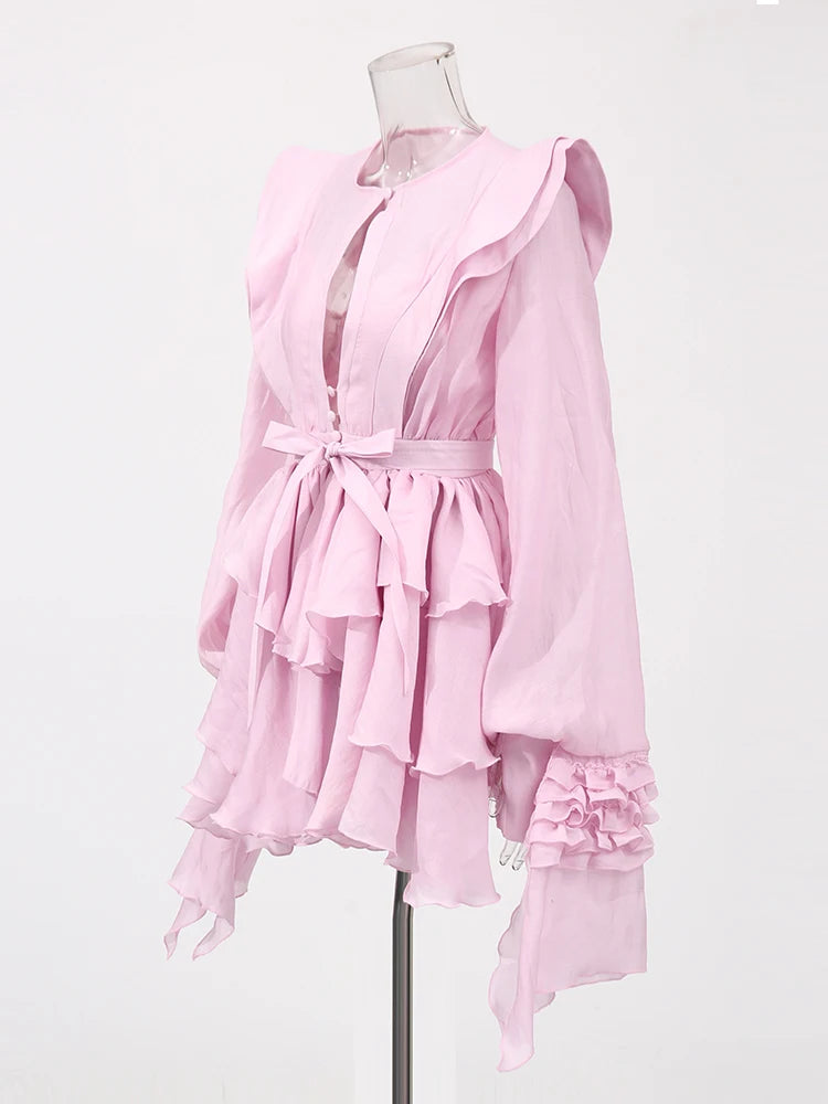Pink dress with ruffled layers on a mannequin against a white background