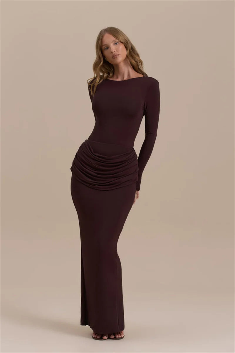 Woman wearing a long burgundy dress against a beige background