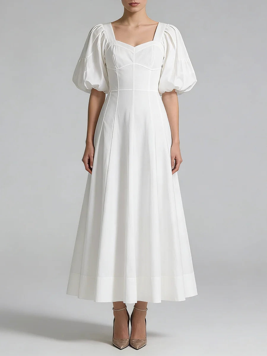 White dress with puffed sleeves on a plain background