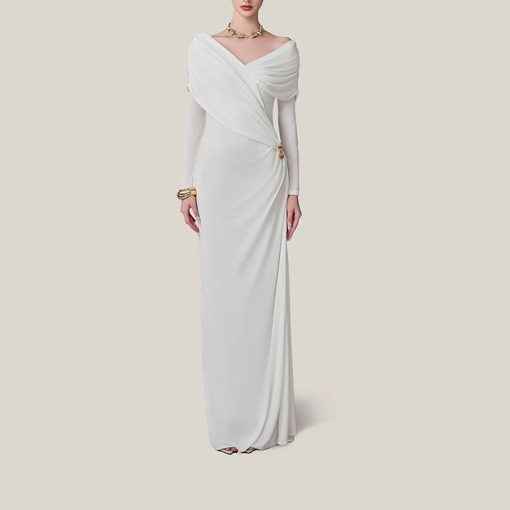 Woman wearing a white evening gown with long sleeves on a plain background