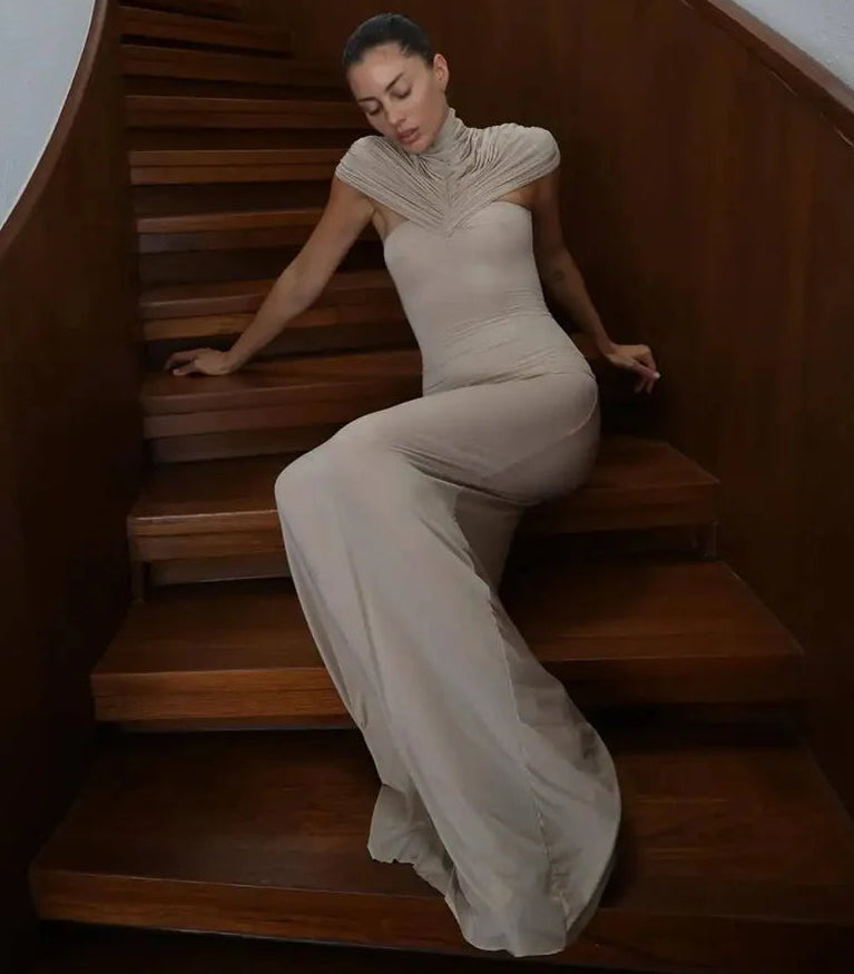 Woman in a beige dress sitting on wooden stairs