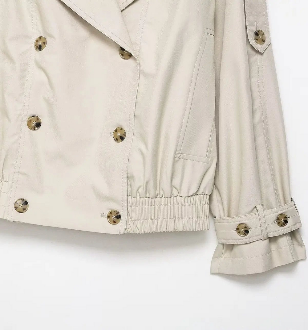 Beige jacket with gold buttons on a white background
