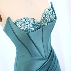 Teal evening gown with intricate beading on a white background