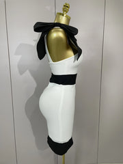 Mannequin with gold head and white body wearing a black bow tie against a plain background