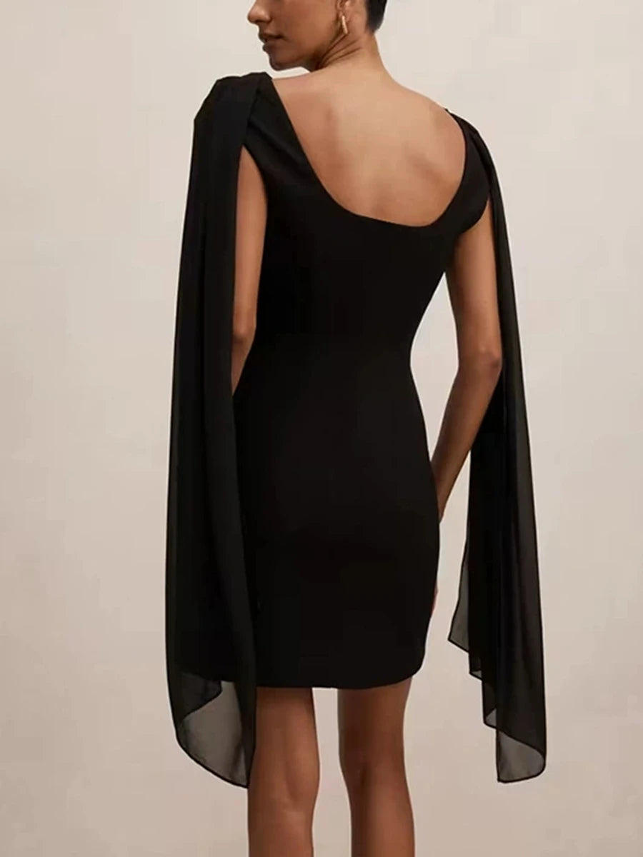 Black mini dress with draped cowl neckline and capelet sleeves, shown from the back.