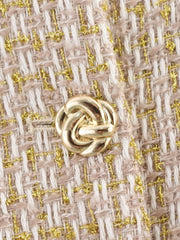 Close-up of a gold knot design on a textured fabric background