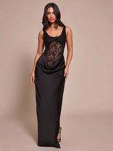 Woman wearing a black evening gown with lace detailing on a beige background