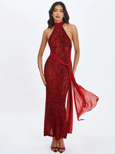 Woman wearing a red leopard print halter neck gown on a white background