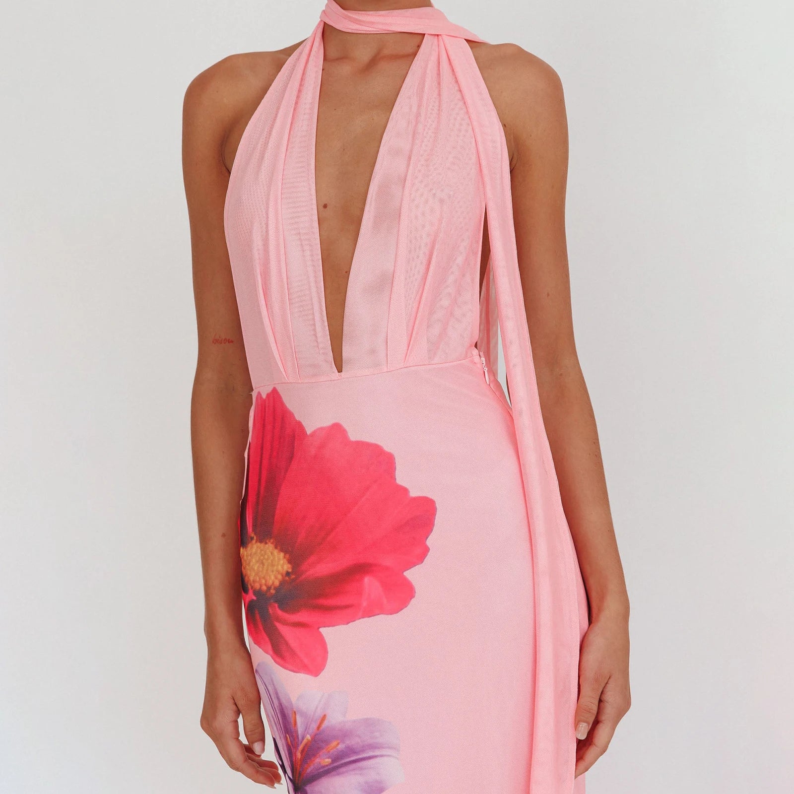 Pink halter neck dress with floral design on a white background